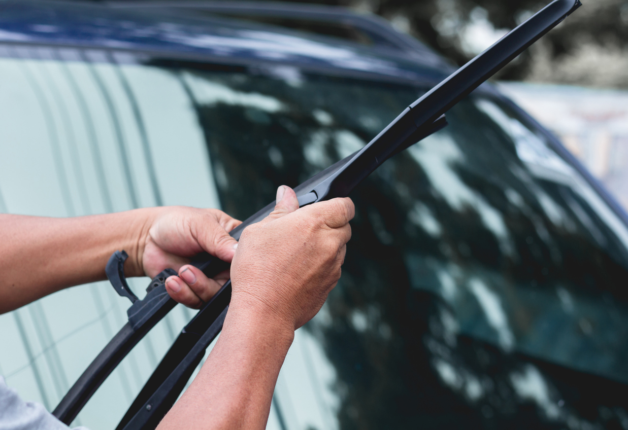 Someone replacing the wiper blades on their vehicle.